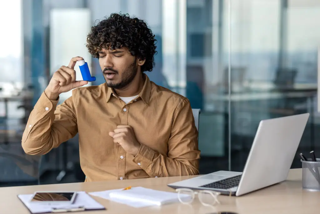 Image of man at work having asthma attack